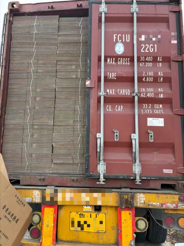 Flat-packed corrugated cartons filling a 40-foot container