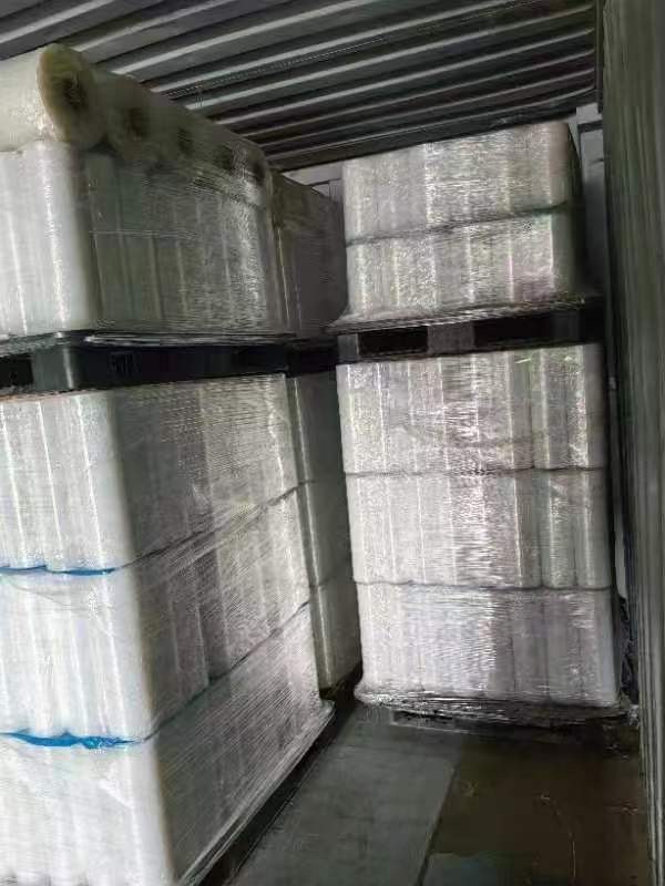 Shrink-wrapped pallets of stretch film rolls inside a container